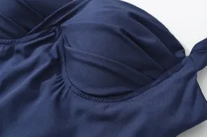 Vista dettagliata del corsetto dell'abito elegante blu scuro con raffinato design plissettato.