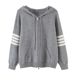 Dettagli in primo piano del cardigan con cappuccio in maglia grigia con zip e maniche a righe.