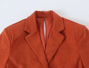 Orange corduroy blazer lapel collar detail, casual women office wear jacket close up.