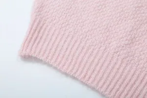 Nahaufnahme des pinken Strickstoff Details mit weicher Textur und geripptem Saum Design.