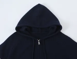 Primo piano dettaglio della felpa con cappuccio in maglia blu scuro zip coulisse.