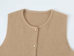 Close-up of women knit vest collar detail, featuring round neck and gold buttons.
