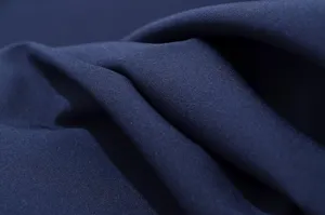 Vista dettagliata del tessuto blu scuro elegante con trama liscia e tessitura fine per abito da donna.