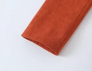 Detail shot of a stylish orange ribbed long sleeve top cuff, soft texture, casual wear.