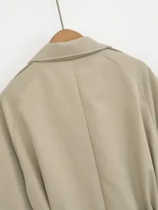 Back view detail of women's khaki trench coat featuring lapel and shoulder epaulet design.