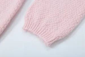 Nahaufnahme der rosa Strickpullover-Manschette mit weicher Textur und feinem Rippstrick.