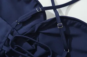 Primo piano dei dettagli delle spalline regolabili dell'abito blu con anelli metallici.