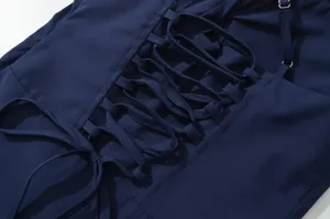 Dettaglio abito blu scuro, design chic con allacciatura posteriore, moda francese elegante.