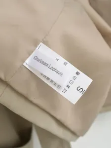 Detail shot of the inner wash tag and size S label on a women's khaki short windbreaker jacket.