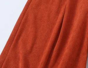 Orange corduroy fabric detail shot, premium textured material for casual elegant apparel.