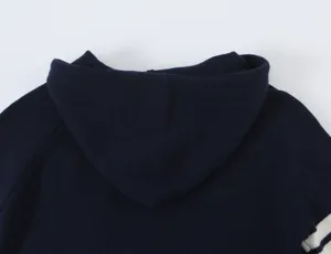 Dettaglio del cardigan con cappuccio donna blu scuro con eleganti righe bianche maniche.