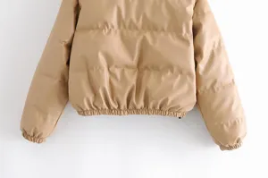 Close-up detailed view of a women khaki faux leather quilted puffer jacket with elastic hem.