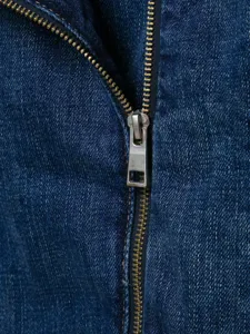 Gedetailleerde opname van donkerblauwe denim kleding met metalen rits en fijne textuur.