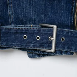 Dames denim bikerjack close-up, stijlvolle blauwe jeansjas met metalen riemgesp detail.