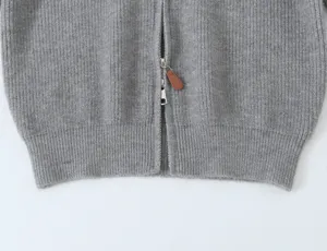 Gros plan sur le cardigan zippé en tricot côtelé gris, montrant la texture et le zip en métal.