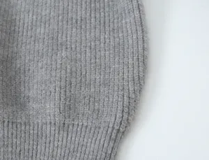 Détail de tissu en tricot côtelé gris, gros plan texture premium pour vêtements de femme.