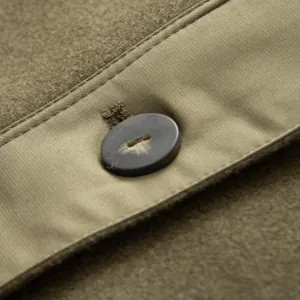 Close-up detail of women winter parka coat featuring button closure and mixed fabric trim.