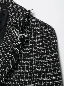 Close up detail of women black and white tweed blazer jacket with frayed lapel collar.