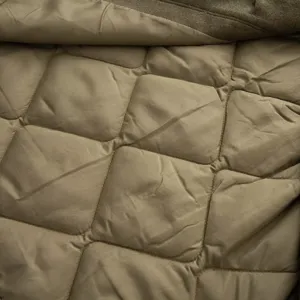 Close-up detail shot of women's parka quilted lining, showing fine stitching and warm texture.