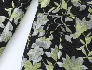 Close-up detail view of women's floral jacquard blazer featuring pocket design and texture.
