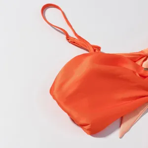 Oranger Bikini-Oberteil-Detail, stilvoller Bademode-Träger und gerafftes Körbchen für Strand.