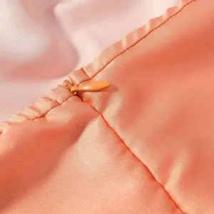 Nahaufnahme des Damenkleidungsdetails, glatter pfirsichfarbener Satin mit verdecktem Reißverschluss.