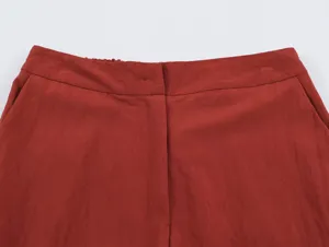 Red trousers waist detail showcasing clean stitching, neat waistband and front closure structure.