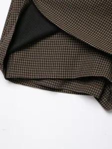 Vista dettagliata della texture del tessuto a quadri marrone da donna con fodera nera.
