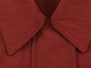 Close-up detail of a burgundy lapel collar with neat stitching, showing high quality fabric.