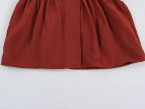 Detailed view of women's safari style apparel featuring gathered fabric and neat stitching.