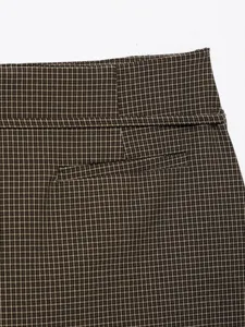 Primo piano sui dettagli della vita alta dei pantaloncini marroni a quadri con tasca.