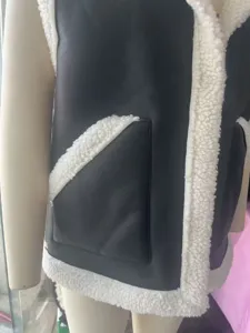 Detalle de chaleco de cuero y felpa con costuras contrastantes y diseño de bolsillo para mujeres.