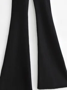 Detailed shot of black ribbed knit flared pants legs, showcasing textured fabric close-up.