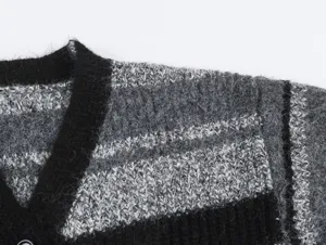 Gros plan détaillé du cardigan en tricot noir et gris avec des rayures duveteuses.