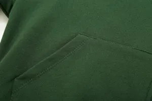Dark green hoodie front pocket detail shot showcasing fine stitching texture and durable cotton fabric.