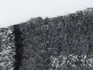 Detail de gilet en tricot avec texture duveteuse douce, tissu en maille mohair grise confortable.