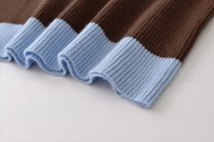 Close-up detail of the stylish contrast color ribbed knit sweater, showing fine texture and edges.
