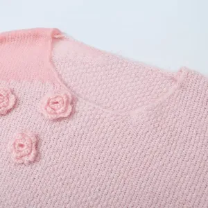 Rosa Strickpullover für Damen mit süßen Häkelblumen und gemütlichem Rundhalsausschnitt.