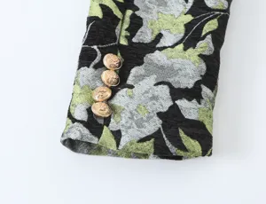 Close-up of women's floral jacquard blazer sleeve with gold metal crest buttons detail.