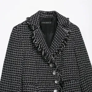 Classic black and white tweed blazer jacket with fringed lapel and stylish metallic buttons.