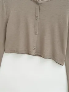 Detailansicht einer schicken khakifarbenen Langarm-Knopfjacke mit weicher Stoffstruktur.