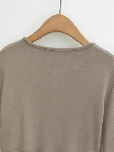 Nahaufnahme des braunen Strick-Langarmtops mit feiner Textur und klassischem Halsausschnitt.