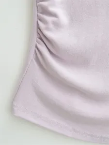 Nahaufnahme des weichen, lila Rippstrickstoffs mit filigranen seitlichen Raffungen.