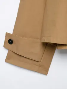 Nahaufnahme des khakifarbenen Damen-Trenchcoat-Ärmelaufschlags mit Knopf und feinen Nähten.