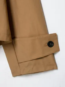 Nahaufnahme der Ärmeldetail eines kurzen Damen-Trenchcoats in Khaki mit Knopfriegel.