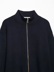 Close-up of a women's dark knit cardigan with a mock neck and gold zipper detail.