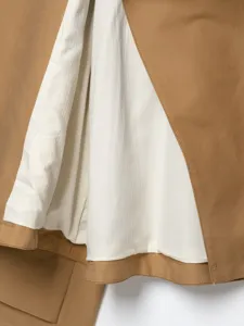 Nahaufnahme des Damen Trenchcoats, Beigefarbener Stoff und weiße Futterstruktur Detail.