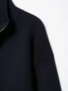 Detail view of stylish navy blue zip-up knitted cardigan with high collar design.