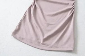 Close-up detail of stylish ruched fabric, showing soft texture and fine hem stitching.