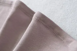 Close-up view of premium knitted fabric texture and fine stitching detail for women's apparel.